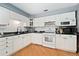 Well-lit kitchen with white cabinetry, black countertops, and modern appliances at 12223 W 60Th Pl, Arvada, CO 80004