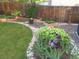 Landscaped backyard with a rock pathway, water fountain, and various plants at 13735 Steele Ct, Thornton, CO 80602