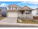 Two-story house with a beige exterior, front porch, and attached garage at 13735 Steele Ct, Thornton, CO 80602