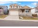 Two-story house with a beige exterior, front porch, and attached garage at 13735 Steele Ct, Thornton, CO 80602