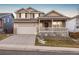 Two-story house with a beige exterior, front porch, and attached two-car garage at 13735 Steele Ct, Thornton, CO 80602