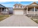 Two-story house with a beige exterior, front porch, and attached garage at 13735 Steele Ct, Thornton, CO 80602