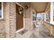 Brick front porch with seating area and a welcoming wreath on the door at 13735 Steele Ct, Thornton, CO 80602