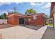 Brick home featuring an expansive concrete patio and secure access with a gated doorway, all under a clear blue sky at 11349 Downing Dr, Northglenn, CO 80233