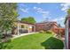 Spacious backyard with a covered patio, lush green lawn, and mature landscaping, perfect for outdoor entertaining at 11349 Downing Dr, Northglenn, CO 80233