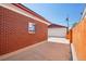 Brick exterior wall with a small window next to a large detached garage at 11349 Downing Dr, Northglenn, CO 80233