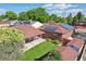 Aerial view showcases a lush backyard with a covered patio, verdant lawn, mature trees, and recently installed solar panels at 11349 Downing Dr, Northglenn, CO 80233