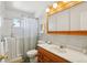 Traditional bathroom with a walk-in shower, wooden vanity, and neutral tile walls at 11349 Downing Dr, Northglenn, CO 80233