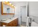 Classic bathroom with white tile, wood vanity, and traditional fixtures at 11349 Downing Dr, Northglenn, CO 80233