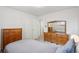 Bedroom with neutral walls, carpet, and vintage wood furniture, including dressers and a mirror at 11349 Downing Dr, Northglenn, CO 80233