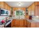 Well-lit kitchen with wooden cabinets, modern appliances, and a double sink under a bright window at 11349 Downing Dr, Northglenn, CO 80233