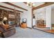 Cozy living room featuring a stone fireplace, beamed ceilings, and comfortable seating at 11349 Downing Dr, Northglenn, CO 80233