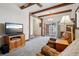 Spacious living room featuring beamed ceilings and sliding doors leading to a back patio at 11349 Downing Dr, Northglenn, CO 80233