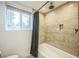Bathroom showing a tub with a shower, plus a window for natural light at 7010 W 44Th Ave, Wheat Ridge, CO 80033