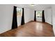 Bright bedroom with hardwood floors, white walls, and windows dressed with curtains at 7010 W 44Th Ave, Wheat Ridge, CO 80033