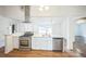 Bright kitchen features stainless steel appliances, white cabinets, and a center island with a sink at 7010 W 44Th Ave, Wheat Ridge, CO 80033