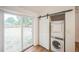 Convenient laundry area with stacked washer and dryer, with sliding glass door and wood-style flooring at 7010 W 44Th Ave, Wheat Ridge, CO 80033
