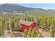 Aerial view of the house among the trees with mountain backdrop at 387 Pine Dr, Idaho Springs, CO 80452
