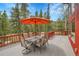 Large back deck with an outdoor dining table, patio umbrella, and scenic views at 387 Pine Dr, Idaho Springs, CO 80452