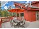 Spacious back deck boasts a dining table, patio umbrella, and views of the mountains at 387 Pine Dr, Idaho Springs, CO 80452