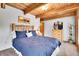 Comfortable bedroom with rustic wooden bed frame and views of the surrounding trees at 387 Pine Dr, Idaho Springs, CO 80452