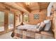 Cozy bedroom with wood-paneled walls, a patchwork quilt, and natural light at 387 Pine Dr, Idaho Springs, CO 80452
