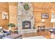 Close up of the living rooms stone fireplace with wood mantel and hearth at 387 Pine Dr, Idaho Springs, CO 80452