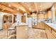 Bright kitchen boasts light wood cabinets, an island, and exposed beam ceiling at 387 Pine Dr, Idaho Springs, CO 80452