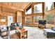 Bright living room featuring wood paneled walls and access to the deck at 387 Pine Dr, Idaho Springs, CO 80452