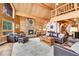 Spacious open living room with wood paneled walls, stone fireplace, and comfortable seating at 387 Pine Dr, Idaho Springs, CO 80452