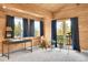 Sunlit living room features wood paneled walls, mountain views, and modern desk area at 387 Pine Dr, Idaho Springs, CO 80452