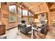 Cozy living room with wood paneled walls, stone fireplace and gorgeous views of the surrounding landscape at 387 Pine Dr, Idaho Springs, CO 80452