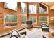 Bright living room with floor to ceiling windows and wood paneled walls at 387 Pine Dr, Idaho Springs, CO 80452