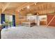 Expansive bedroom with rustic bed frame, private bath, and wood-paneled walls at 387 Pine Dr, Idaho Springs, CO 80452