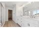 Bright bathroom featuring double sinks with white countertops and a large mirror at 660 Split Rock Dr, Erie, CO 80516