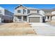 Two-story home showcasing a well-manicured lawn, a two-car garage, and a welcoming front porch at 660 Split Rock Dr, Erie, CO 80516