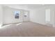 Bright living room featuring neutral walls and carpet, with natural light from large windows at 660 Split Rock Dr, Erie, CO 80516