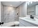 Renovated bathroom featuring modern fixtures and a tiled shower at 3033 Leyden St, Denver, CO 80207