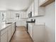 Bright kitchen features white cabinets, stainless steel appliances, and center island with quartz countertops at 9061 Telluride Ct, Commerce City, CO 80022