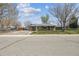 Charming single-story home featuring a well-maintained front yard and mature trees at 6860 Krameria St, Commerce City, CO 80022