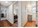 Clean hallway with hardwood floors leading to office area, featuring a conveniently located half bathroom at 6860 Krameria St, Commerce City, CO 80022