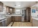 Updated kitchen with a stainless steel refrigerator, wooden cabinets, and attractive countertops at 6860 Krameria St, Commerce City, CO 80022