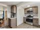 Efficient kitchen layout with stainless appliances and wood cabinets, optimizing storage and functionality at 6860 Krameria St, Commerce City, CO 80022