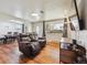 Comfortable living room featuring a plush leather recliner, hardwood floors, and a sun-filled window at 6860 Krameria St, Commerce City, CO 80022