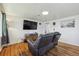Cozy living room boasting hardwood floors, a large flat-screen TV, and comfortable seating, perfect for relaxation at 6860 Krameria St, Commerce City, CO 80022