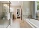 Spa-like bathroom featuring a soaking tub, glass-enclosed shower, and serene decor with natural light at 1235 S Balsam St, Lakewood, CO 80232