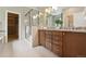 Bathroom with a walk-in closet, a glass shower, granite countertops, and wood cabinets with double sinks at 1235 S Balsam St, Lakewood, CO 80232