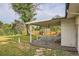 Backyard view of the covered patio, lush green grass and landscaping at 2996 S Sheridan Blvd, Denver, CO 80227