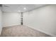 Neutral basement room with carpeted floor, a window and built in shelves at 2996 S Sheridan Blvd, Denver, CO 80227