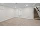 Open basement room with carpeted floor, a window and a staircase at 2996 S Sheridan Blvd, Denver, CO 80227